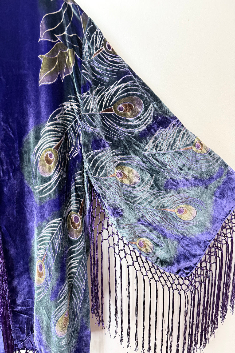 Velvet silk jacket with peacock feather design on a white background